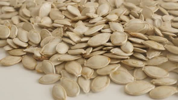 Close-up of healthy pumpkin seed tilting footage. Lot of edible pepitas on pile slow tilt