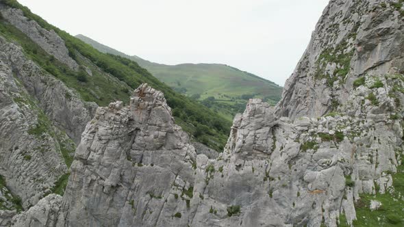 Cinematic aerial view flying between mountain rocks in Asturias, Spain. Rural tourism