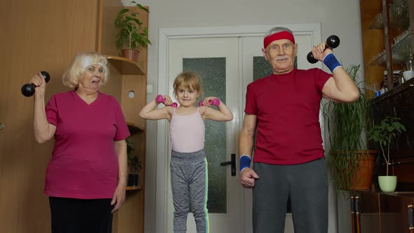 Active Senior Couple Grandmother Grandfather with Child Kid Girl Doing Fitness Dumbbells Exercises