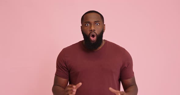 Young African American Man Schocked Isolated on Pink Background