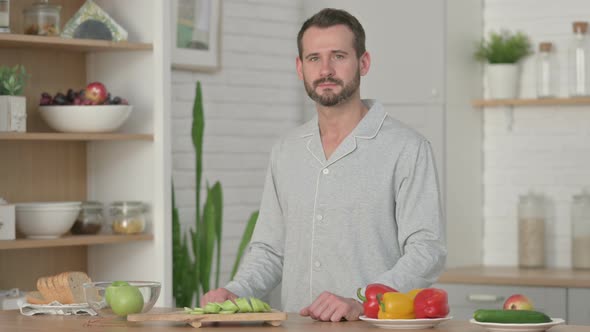 Young Man Looking at the Camera While Standing in Kitchen