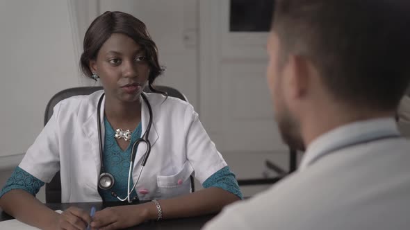 Doctor In White Coat Examining Male Patient In Office, Blood Pressure, African American Black Nurse