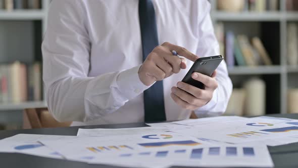 Close Up Shoot of Businessman Using Cellphone on Office Desk