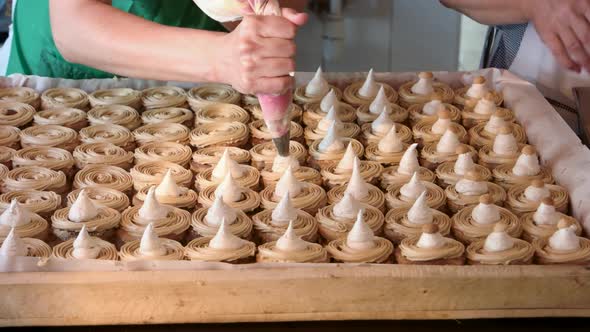 Worker Applying Cream on Cookies at Bakery