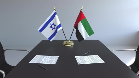 Flags of Israel and the UAE and Papers on the Table
