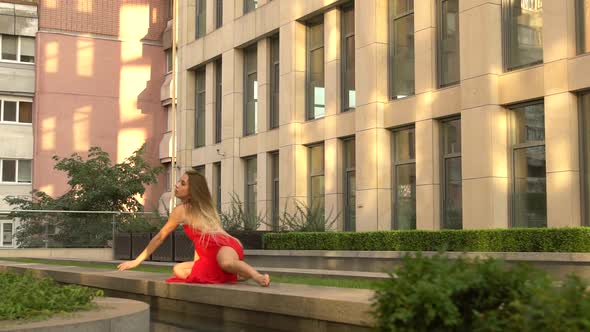 Beautiful Young Girl Dancing on the Street of a Modern City and Is Reflected in the Water