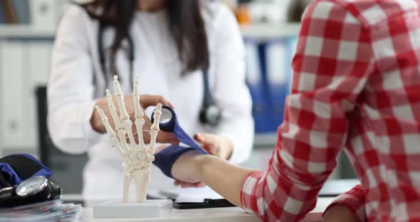 A Doctor Puts a Bandage on a Woman's Wrist