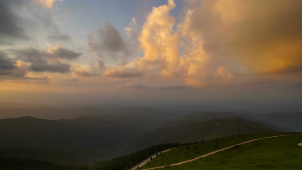 Time lapse of clouds at sunset over mountain road