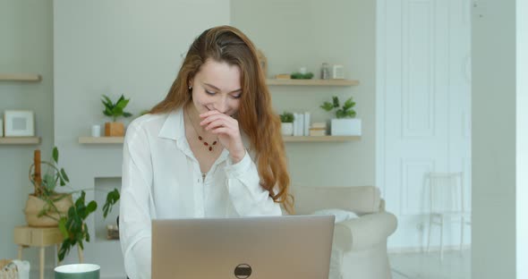 Young Woman Using Laptop Computer. Portrait of Business Woman Watching News at Laptop Screen and