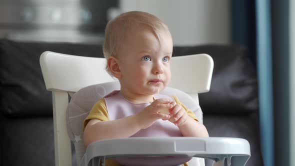 Cute Kid Sitting in Booster Seat with Feeding Tray Fixed on Top of Dining Chair One Year Old Baby