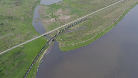 A Drone View of a Freight Train Driven By a Diesel Locomotive on a Railroad