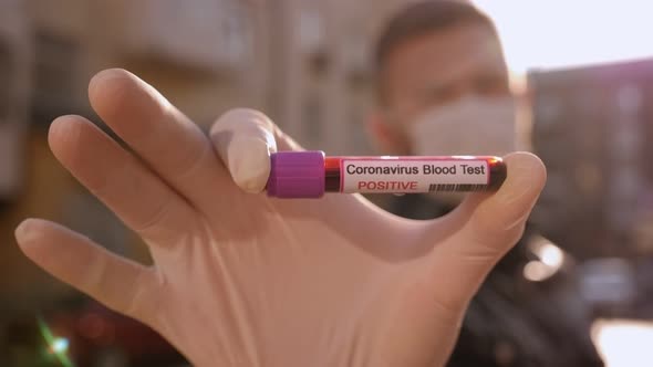 Closeup of Man in Gloves Holding a Test Tube with a Blood Test for Coronavirus