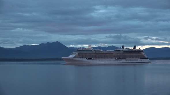 Sea cruise ship along the coast of Alaska. Colorful sunset in the mountains of Alaska.