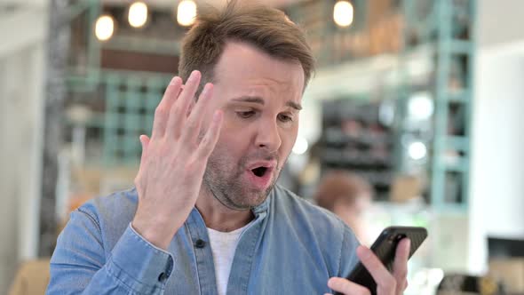 Portrait of Casual Man Reacting to Loss on Smartphone