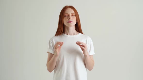 Portrait of Calm Young Woman Deeply Breathing with Closed Eyes Holding Fingers in Mudra Om Position