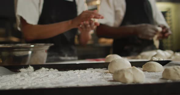 Animation of hands of diverse male and female bakers preparing rolls