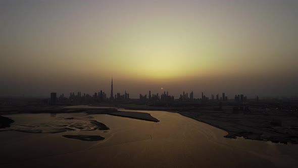 Aerial view of Dubai skyscrapers and bay at sunset, UAE.