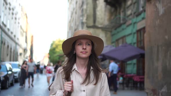 Beautiful Girl in a Hat Walking Through the Old Town