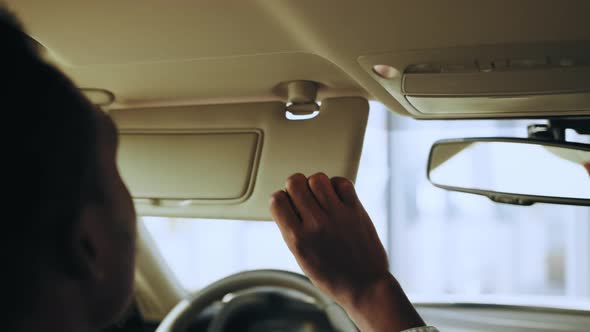 Close Up of African Man Sitting Inside Luxury Car and Examining Interior Before