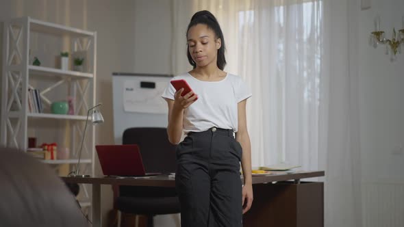 Irritated Overwhelmed Young Woman Hanging Up Phone Sighing Looking at Camera Standing in Home Office