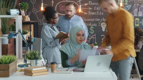 Time Lapse of Muslim Employee in Hijab Working with Laptop and Discussing Business with Colleagues