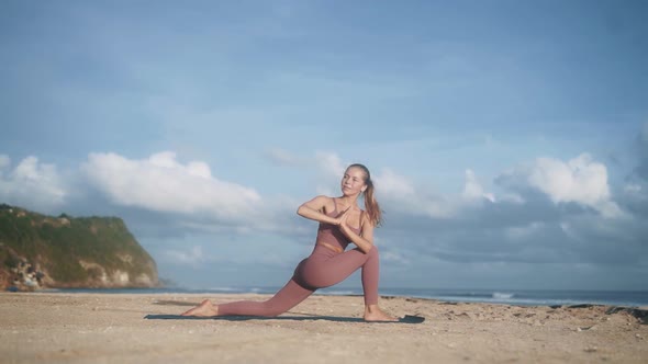 Woman in Violet Tracksuit Does Yoga Pose Stretching Arms
