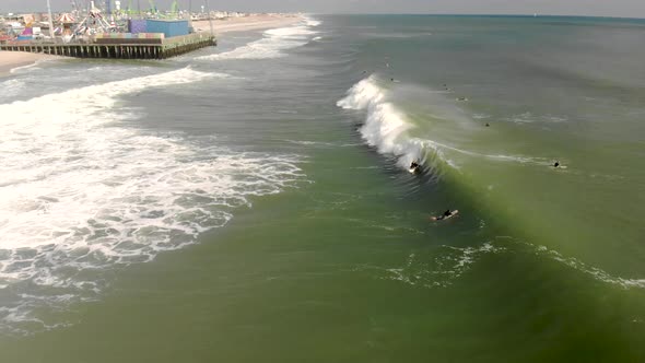 Epic drone tracking shot of surfer riding a wave.