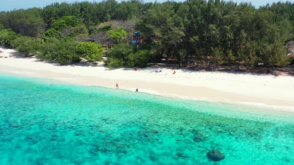 People swim, snorkel on clear water of calm turquoise lagoon and sunbathe on white sand of exotic be