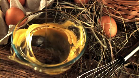 Super Slow Motion Raw Egg Falls Into a Transparent Bowl on the Table