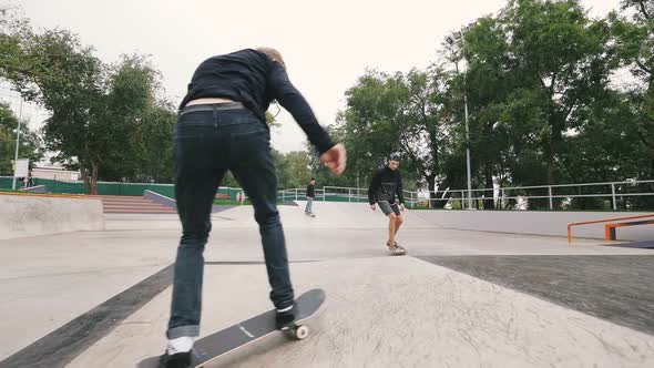 Three Skateboarders in Skate Park Doing Tricks Slow Motion