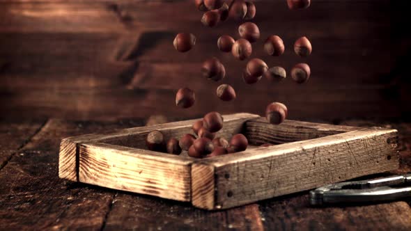 The Super Slow Motion of the Hazelnut Falls on the Wooden Tray