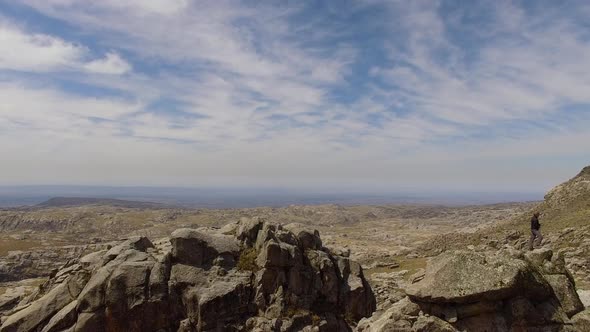 Hiker standing on top of jagged rock formation, Mount Champaqui, Cordoba Province, Argentina