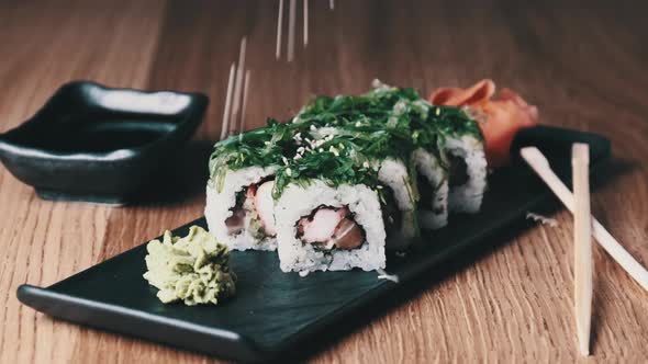 Sprinkle Sushi with Sesame Seeds on a Wooden Table in Restaurant