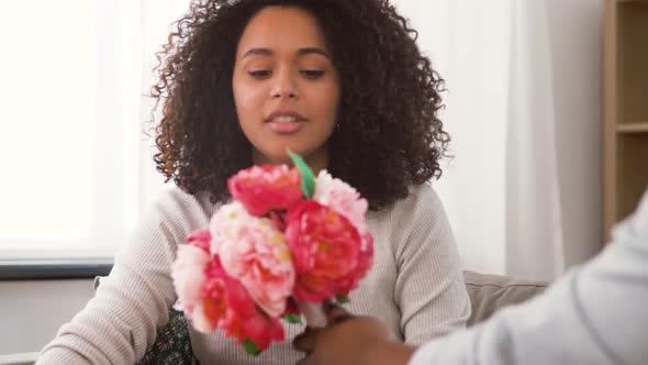 Happy Couple with Bunch of Flowers at Home