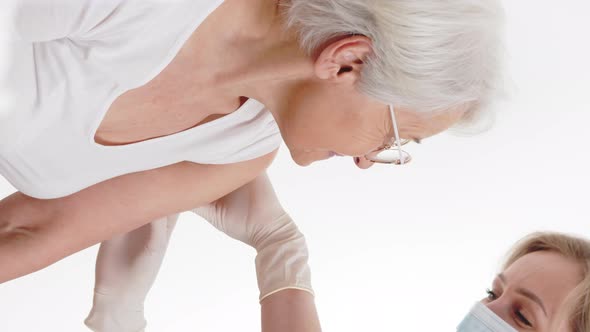 A Delighted Old Grayhaired Woman Receiving a Vaccine to Protect Herself Against the Virus