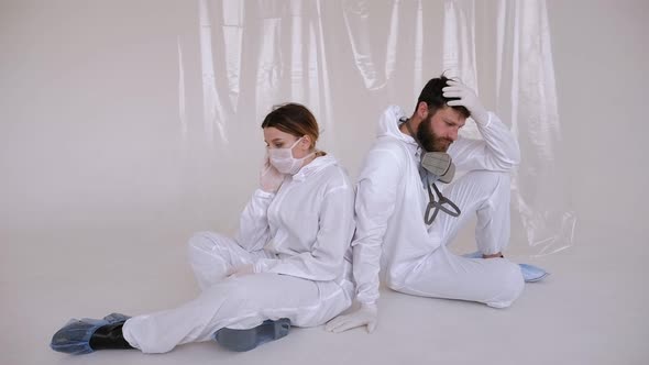 Tired Doctors in PPE Suit Sitting and Sleeping on the Floor
