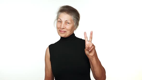Slow Motion Joyful Older Lady with Grey Tied Hair Looking at Camera Smiling with White Teeth Showing