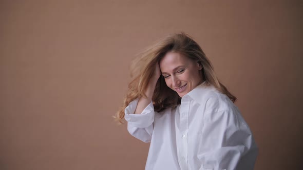 Elegant Professional Model in the White Shirt Posing to a Camera in the Studio