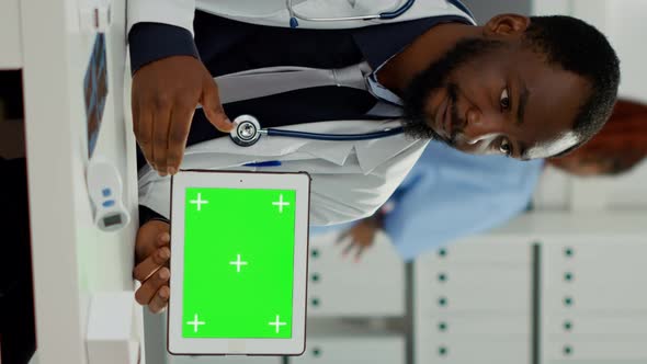 Vertical Video Male Specialist Holding Tablet with Horizontal Greenscreen