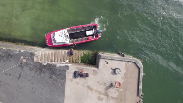 A Small Passenger Ferry Moored on a Jetty Loading Passenger Bags