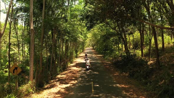 Couple of European Man and Woman in Helmets on Motorcycles Ride Along the Road