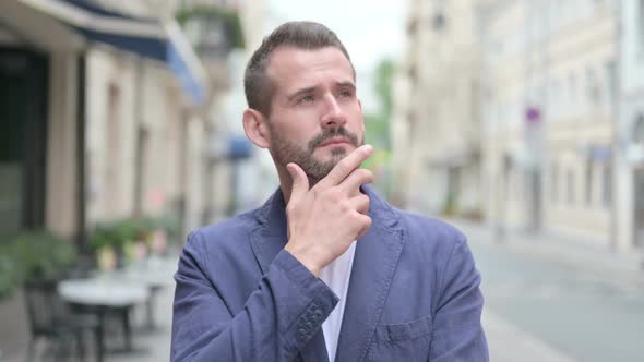 Outdoor Portrait of Pensive Mature Adult Man Thinking