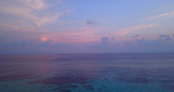 Beautiful above island view of a paradise sunny white sand beach and turquoise sea background in 4K