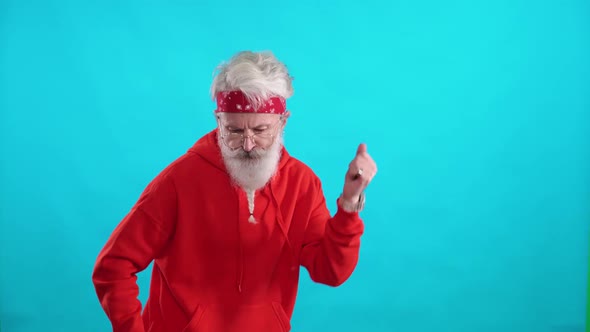 Adult Grayhaired Man in a Red Hoodie Dancing to the Music on a Blue Background a Cheerful Man is