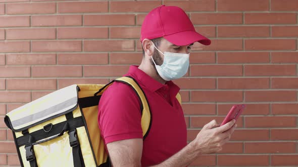 Young Delivery Man Using Mobile Phone While Delivering a Package to a Costumer