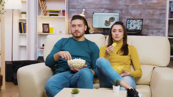 Young Couple Relaxing on Sofa Watching Tv