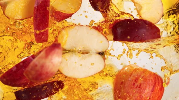 Super Slow Motion Shot of Red Apple Cuts Falling and Splashing Into Juice at 1000Fps alt