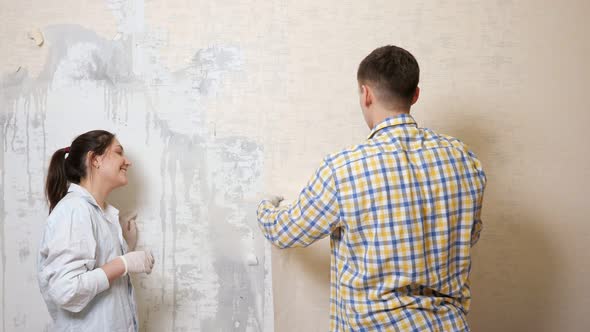 Guy in Checkered Shirt Removes Piece of Old Wallpapers