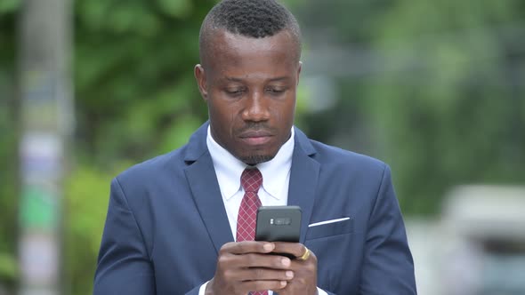 Young Happy African Businessman Using Phone Outdoors