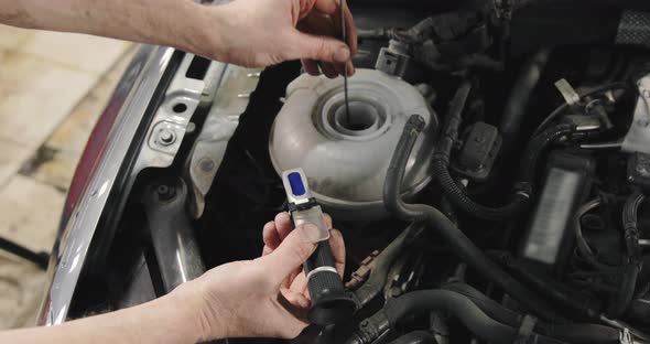 Car Mechanic Checking Antifreeze In The Car. Antifreeze Test